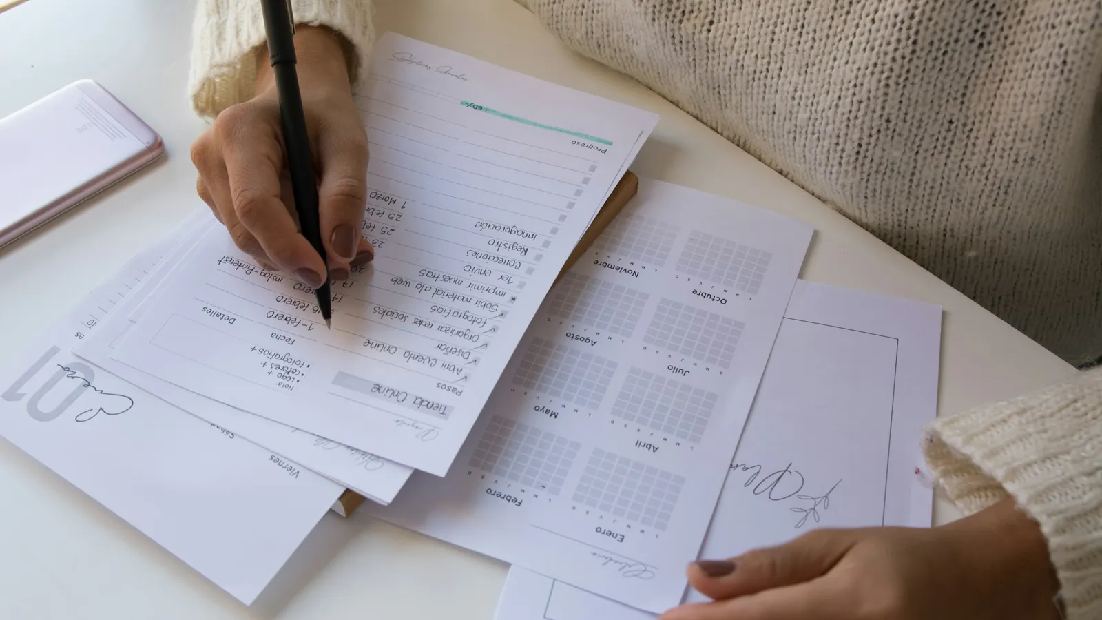 Hands marking a stack of papers