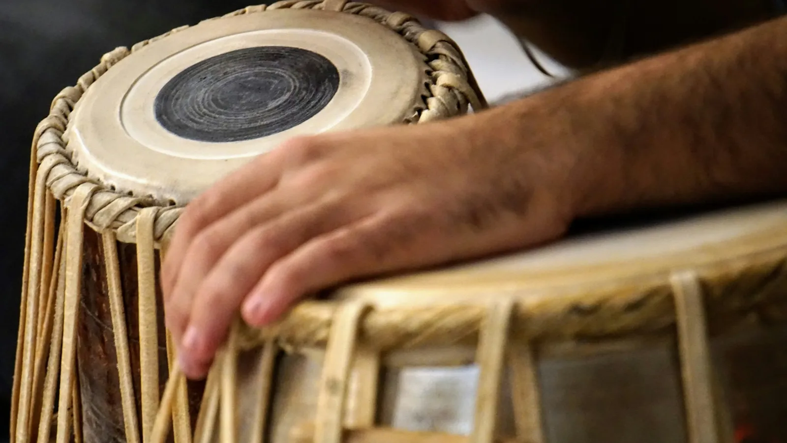 Hands playing a pair of tabla drums