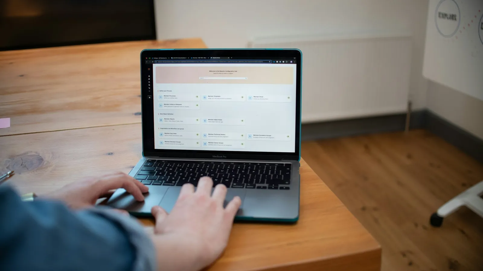 Hands typing on a laptop open on a wooden desk
