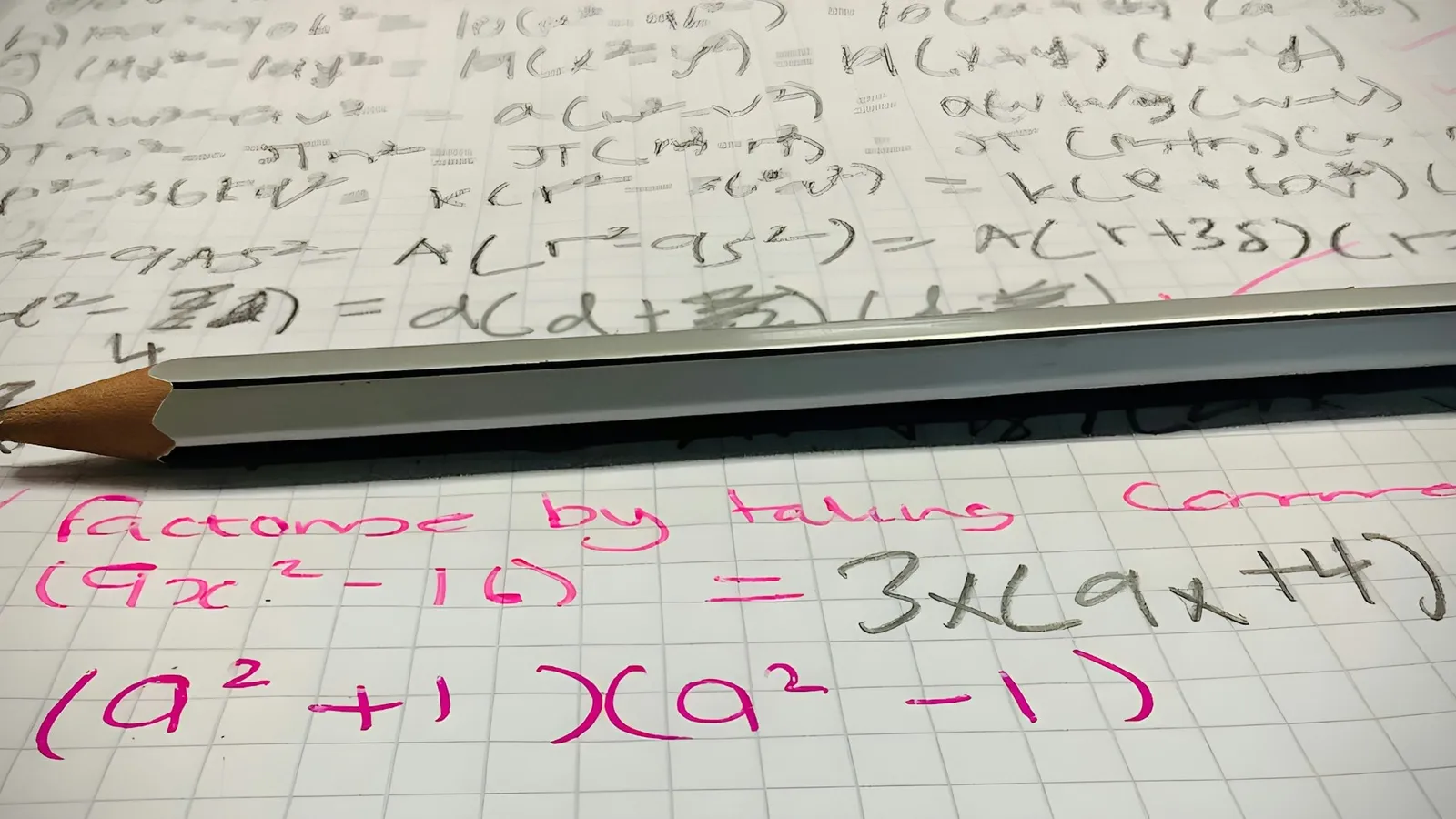 Handwritten algebra formulas on grid paper with a pencil