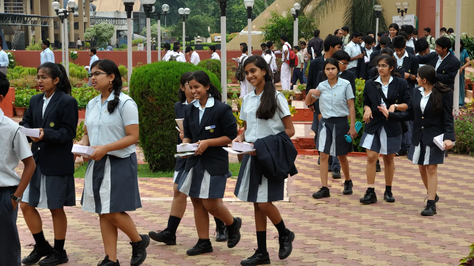 Indian high school students in uniform walking and chatting together outdoors