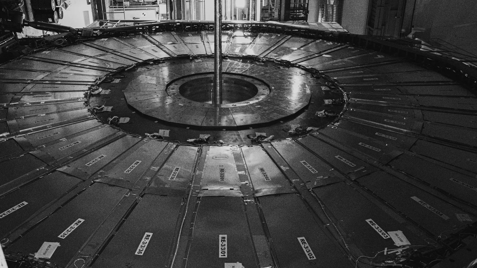Inside a large circular particle accelerator, in black and white