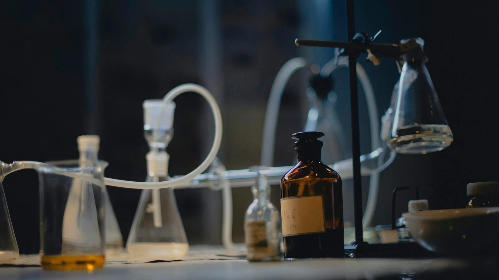 Laboratory glassware on a dark, lit lab bench