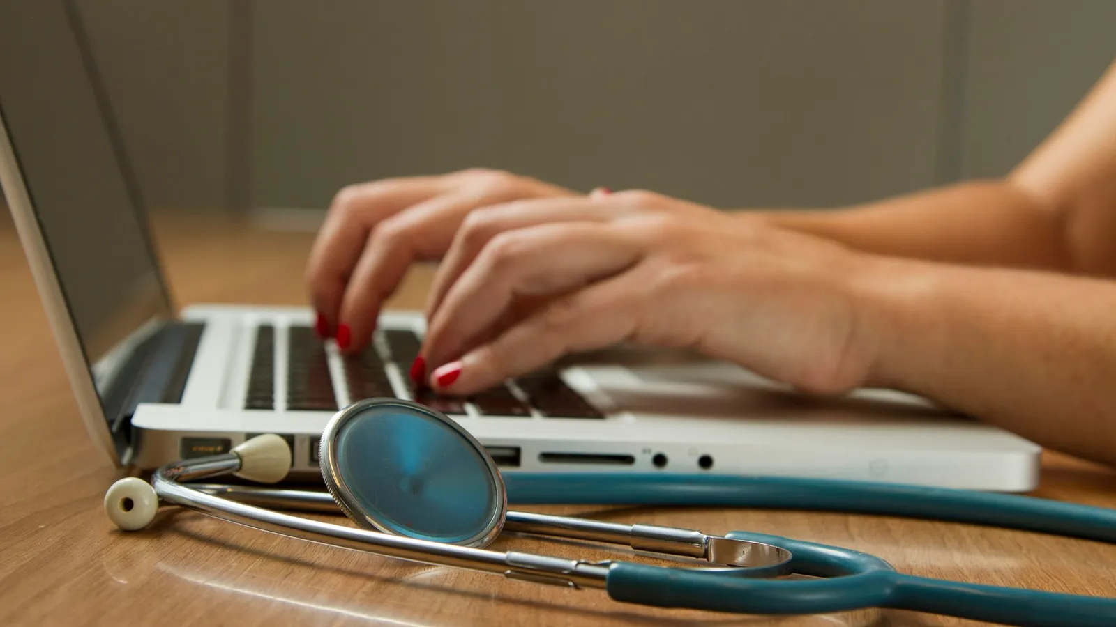 Laptop and stethoscope on a desk