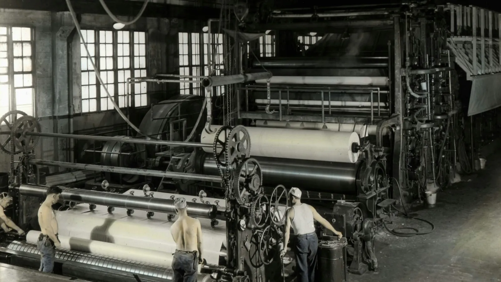 Large machines in an old factory hall, in black and white