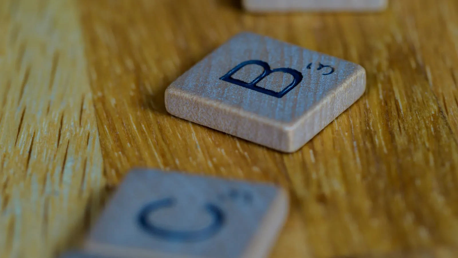 Letter tiles B and C on a wooden table