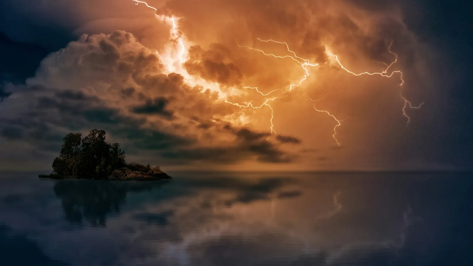 Lightning striking from storm clouds over dark water
