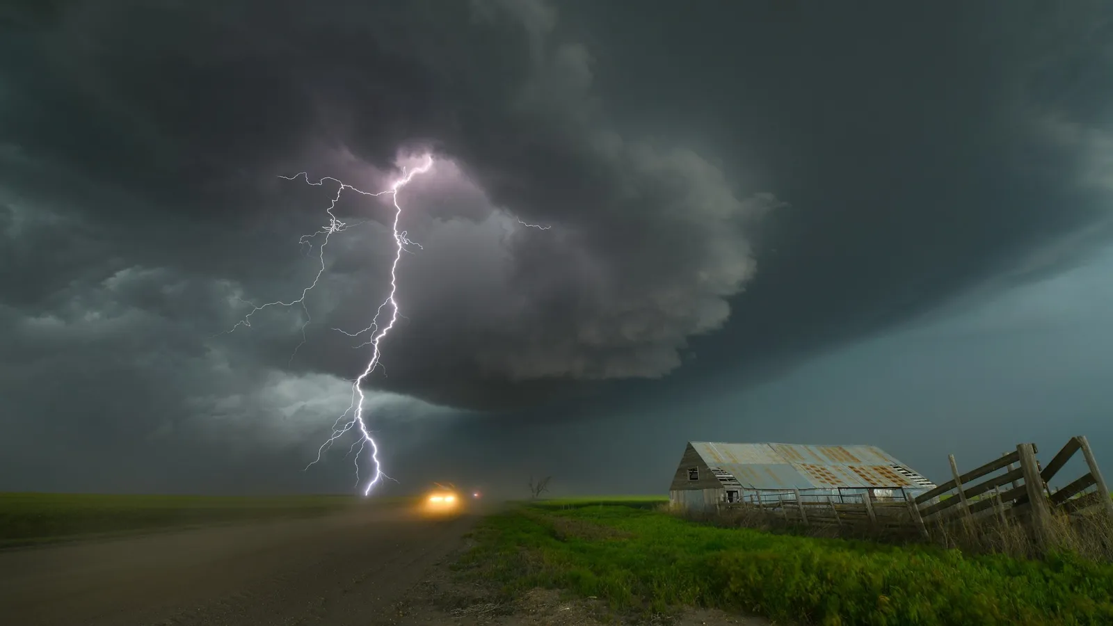 Lightning striking from storm clouds over open land