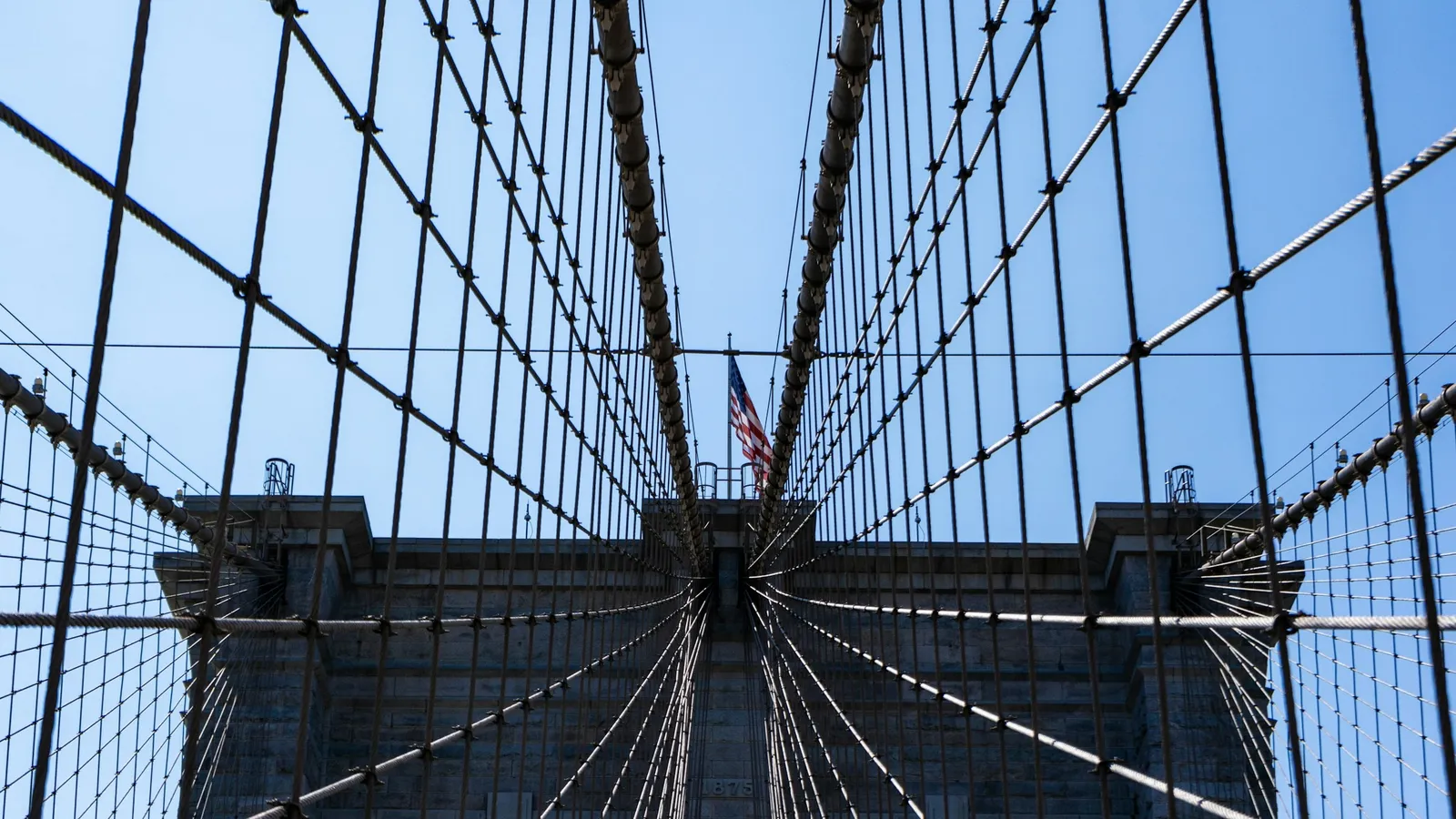 Looking up at the steel cables of a suspension bridge