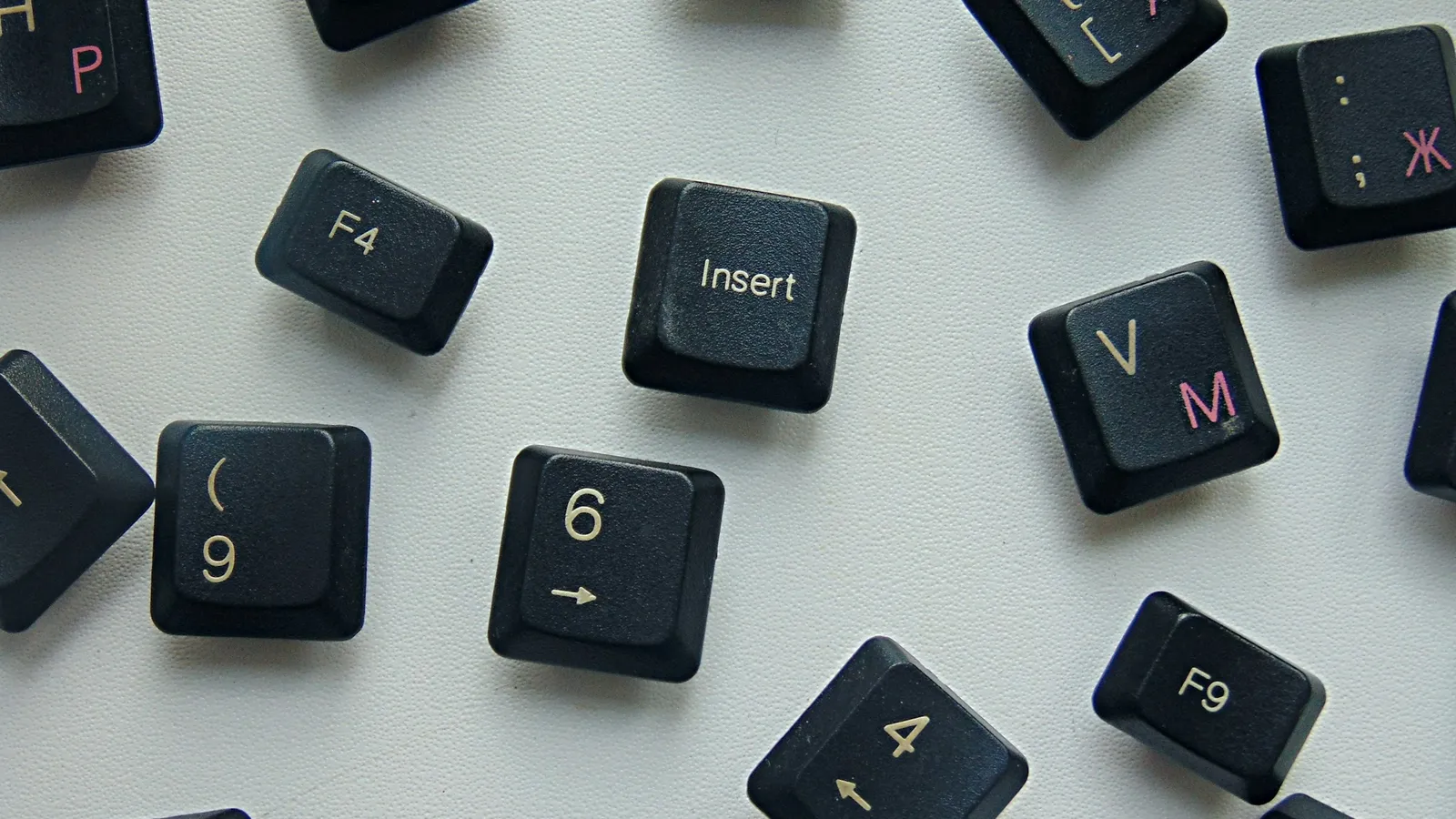 Loose keyboard keys with letters scattered on grey