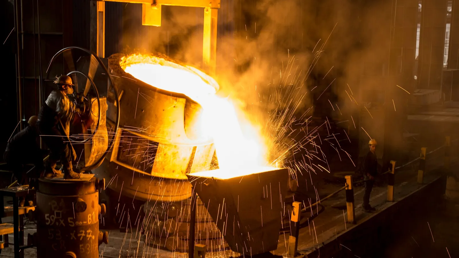 Molten metal pouring with sparks in a steel works