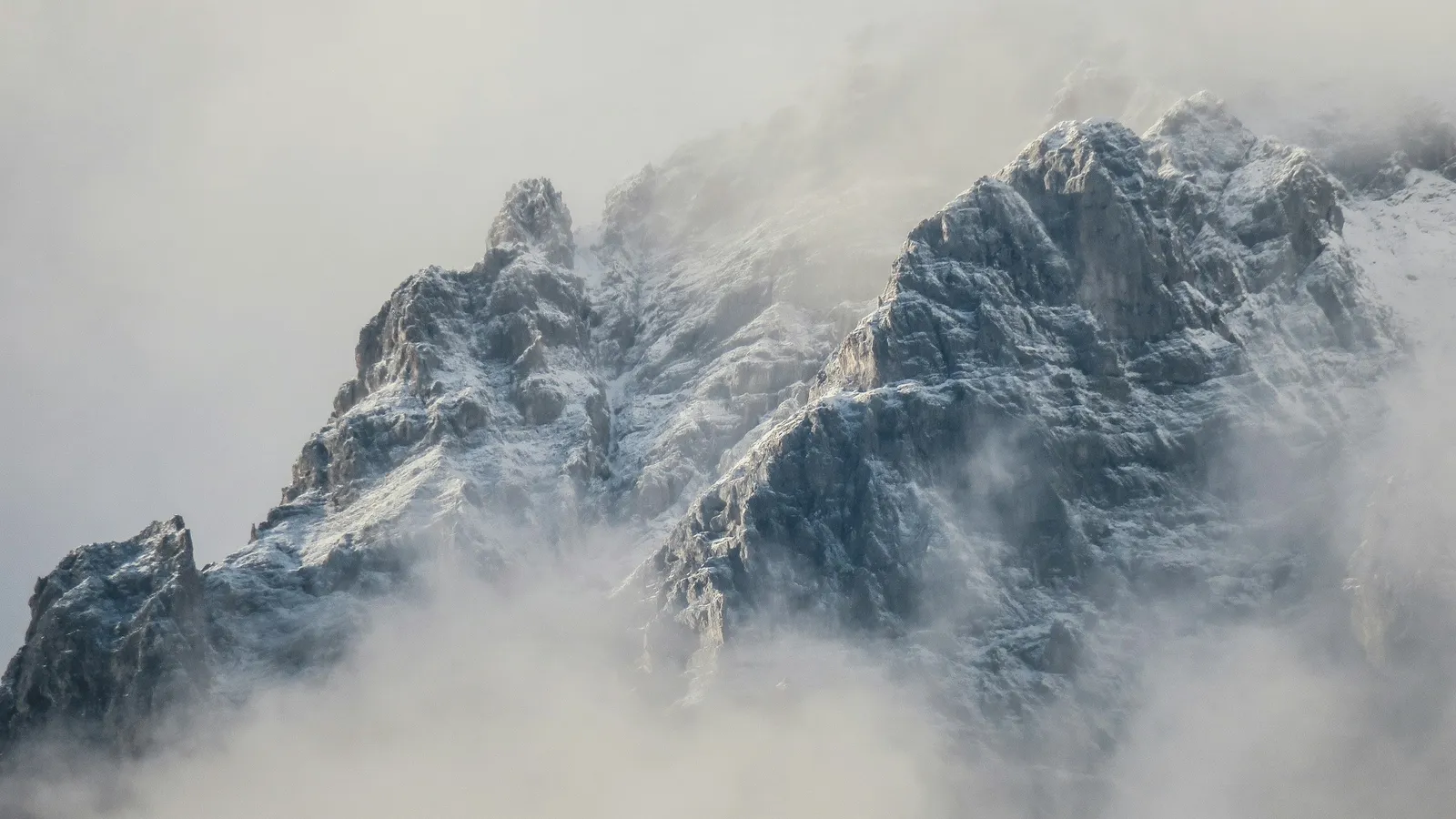 Mountain peaks rising through thick cloud