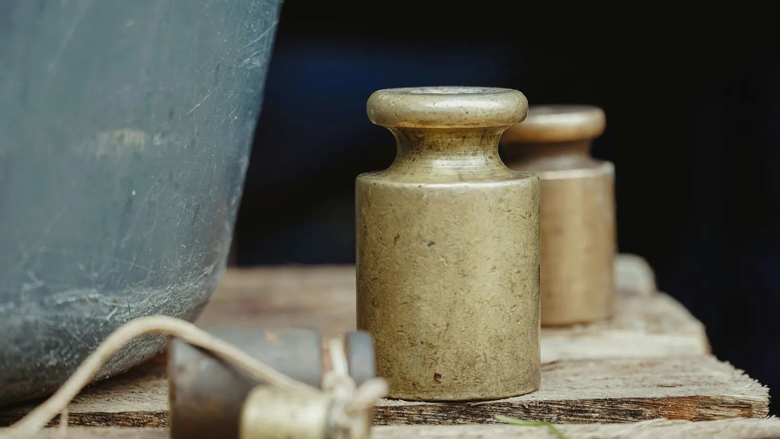 Old brass balance weights on a wooden surface