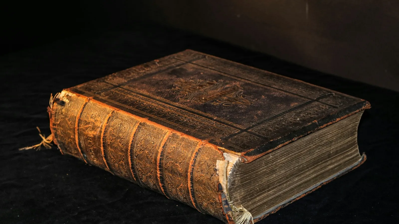 Old leather-bound book on a dark table