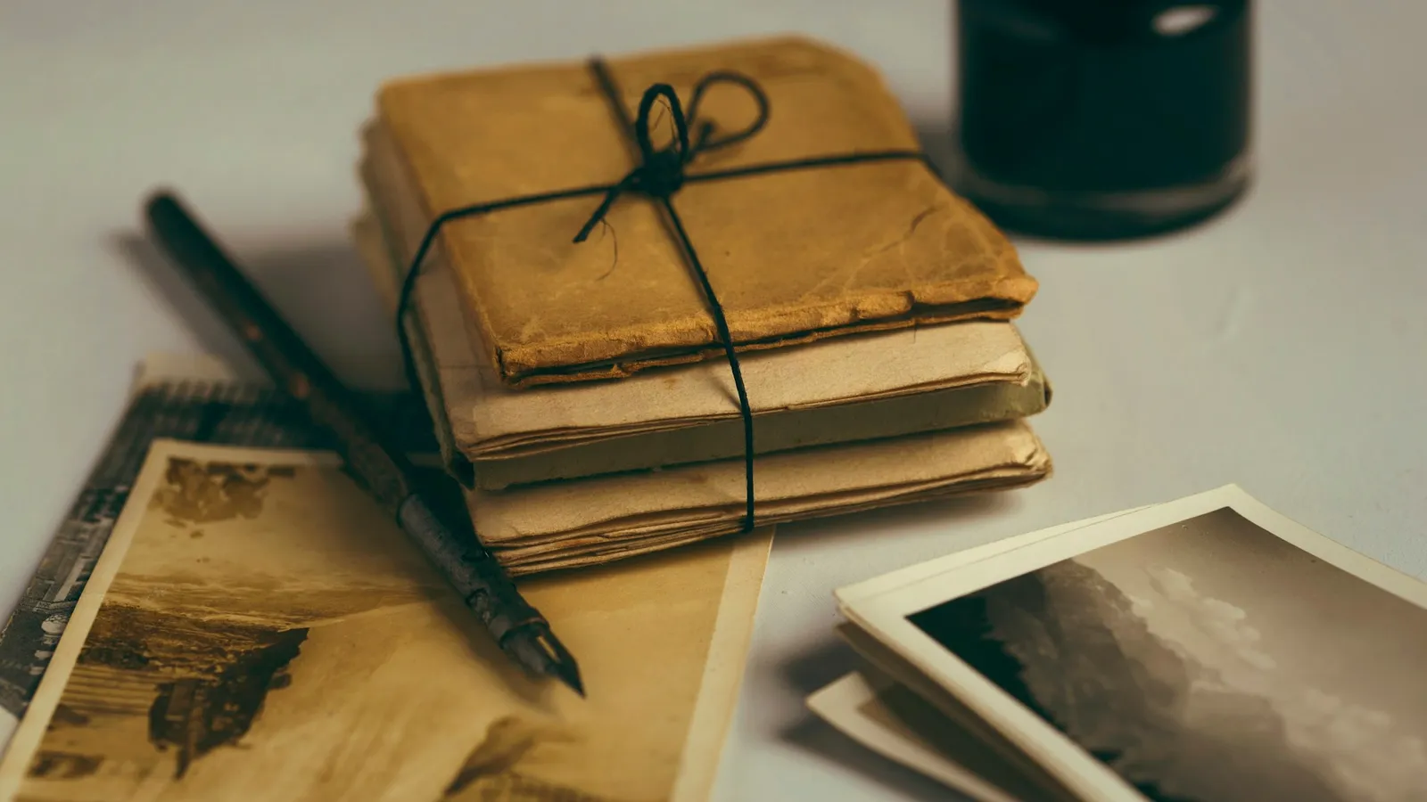 Old papers tied with string beside a pen and ink
