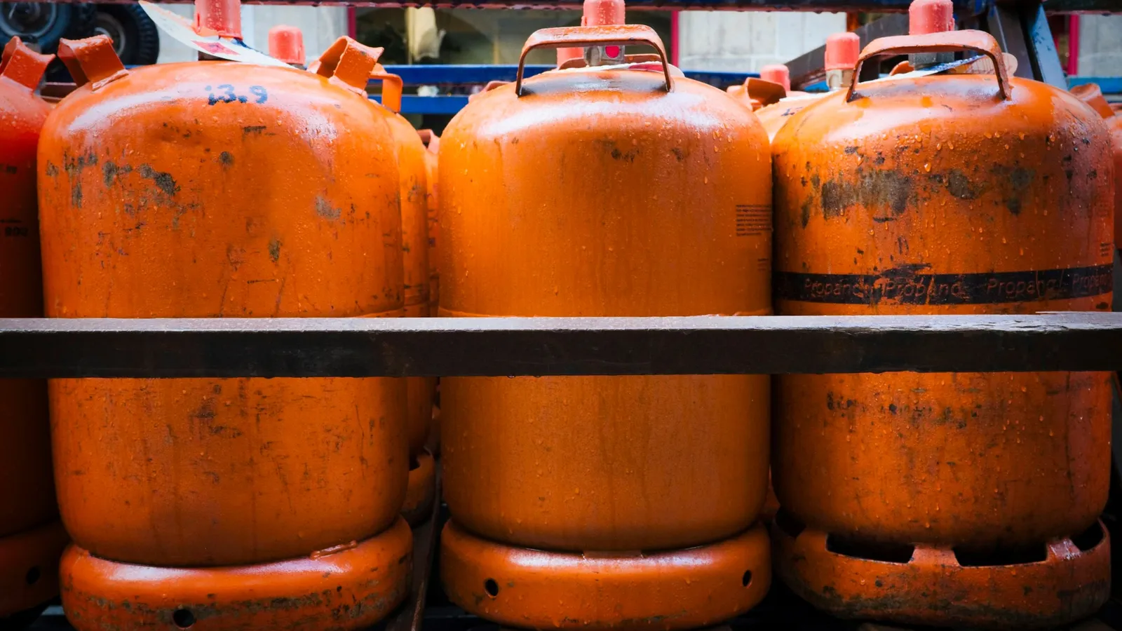 Orange gas cylinders lined up on a rack
