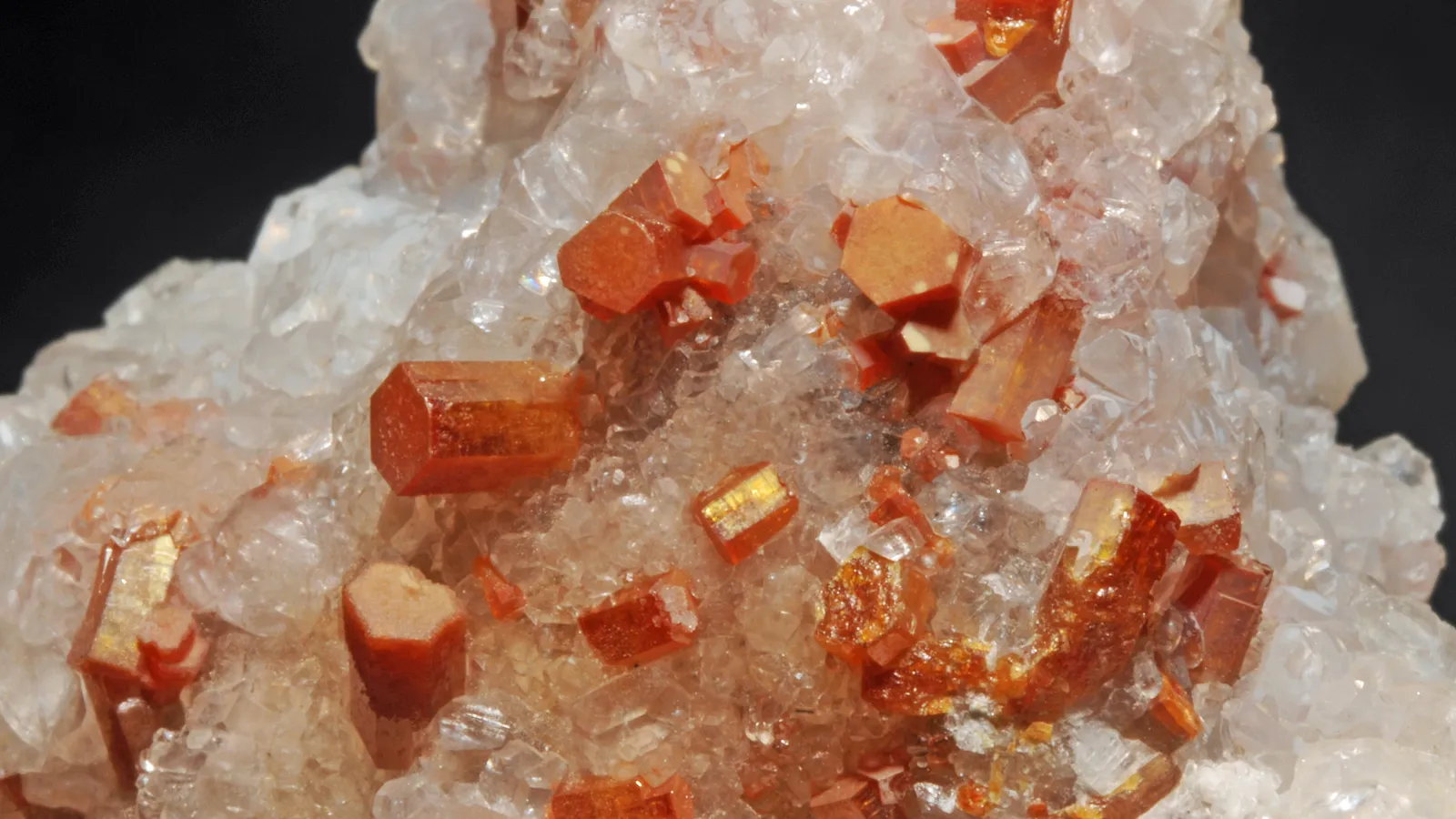 Orange hexagonal vanadinite crystals on pale calcite from a Mexican mine
