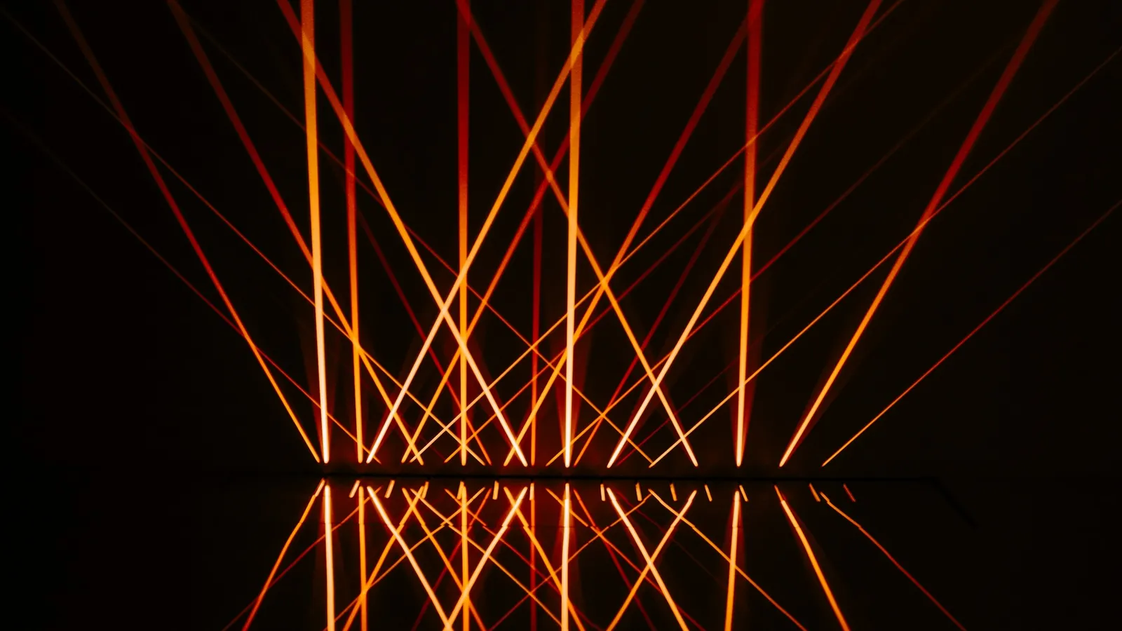 Orange laser beams crossing in the dark
