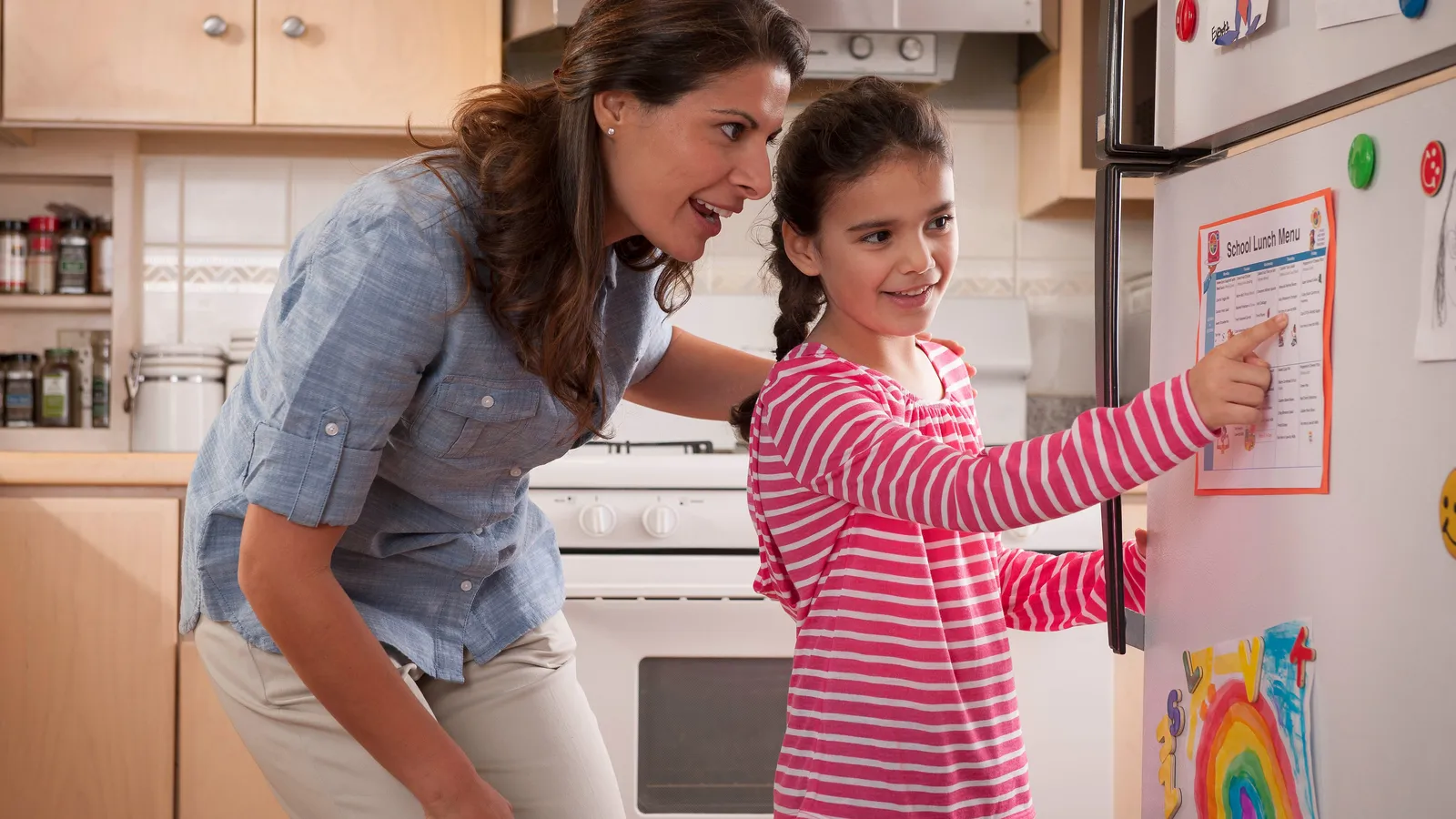 Parent and child talking near a refrigerator