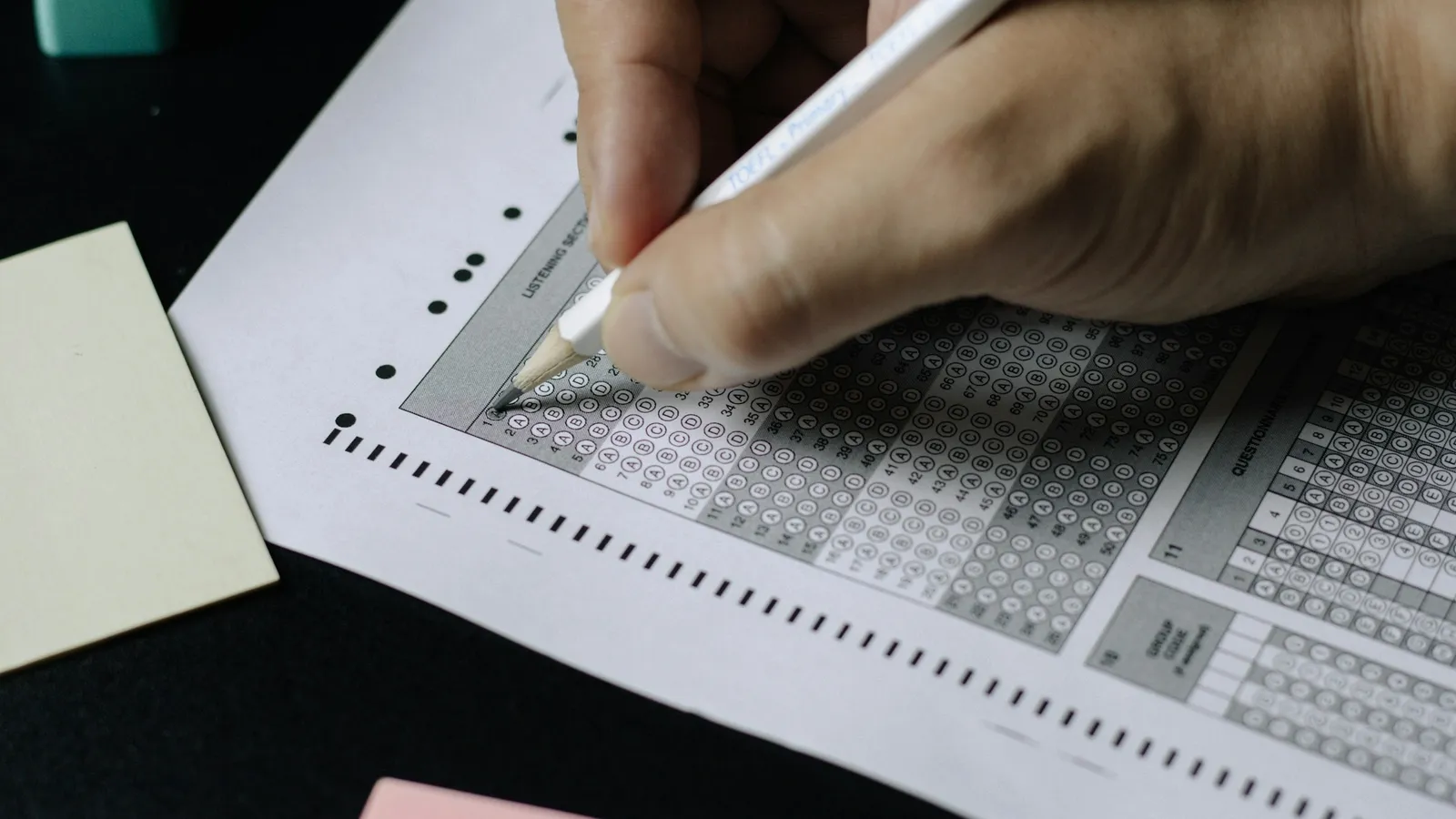 Pencil filling in bubbles on a multiple-choice answer sheet