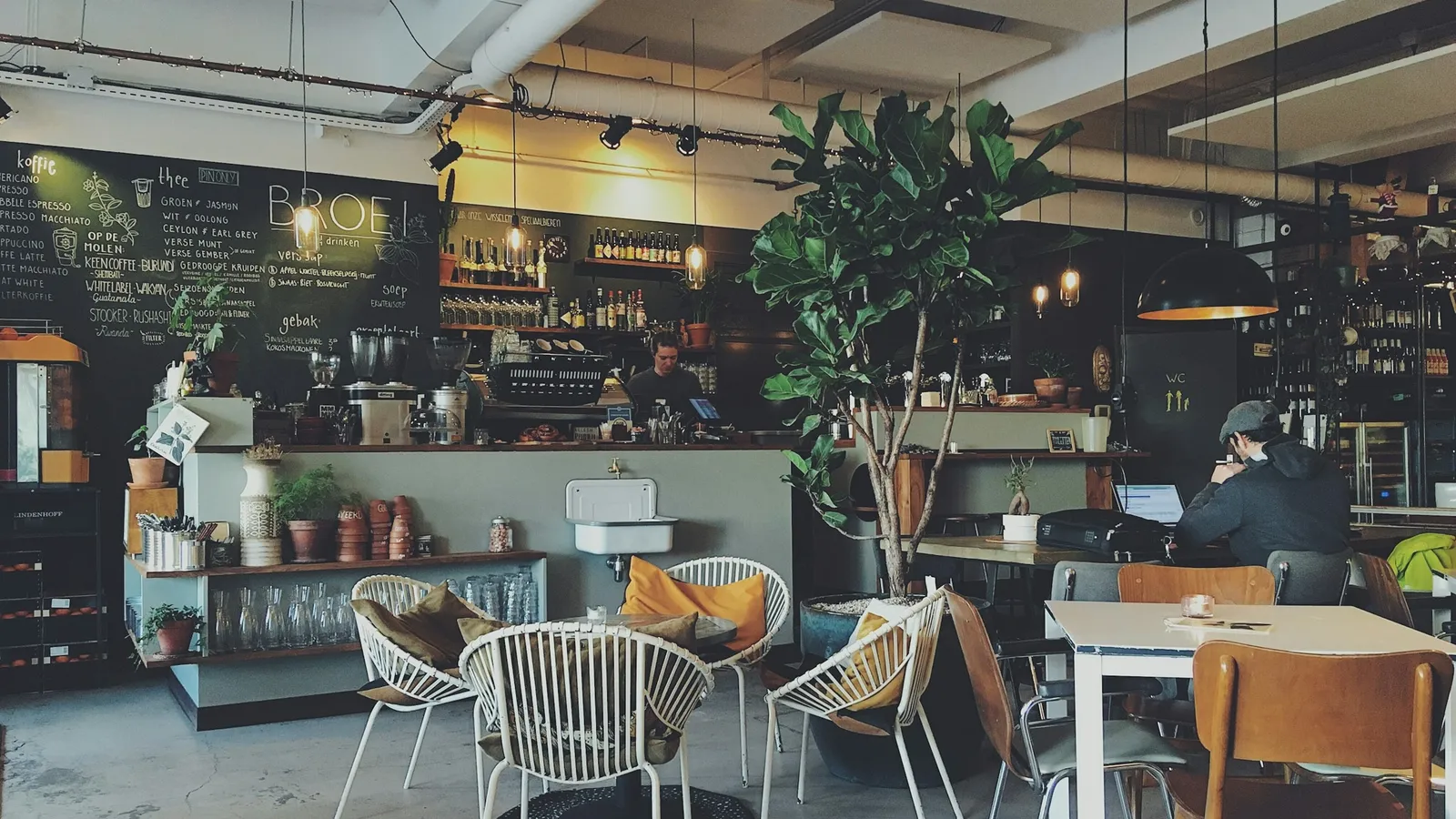 People working at tables in a busy cafe