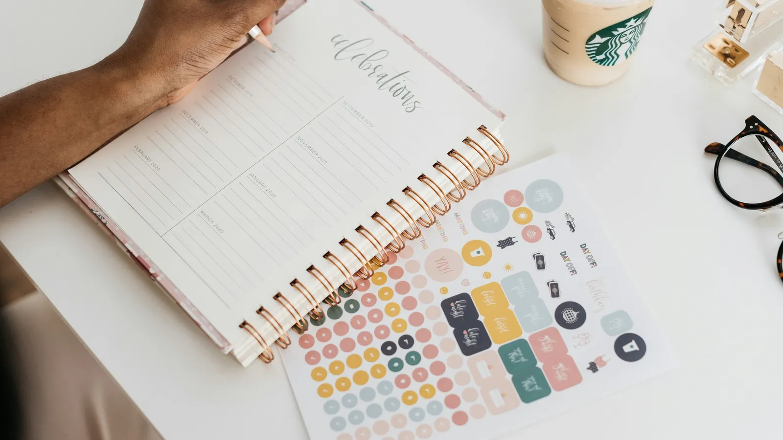 Planner open on a desk with coloured stickers for scheduling