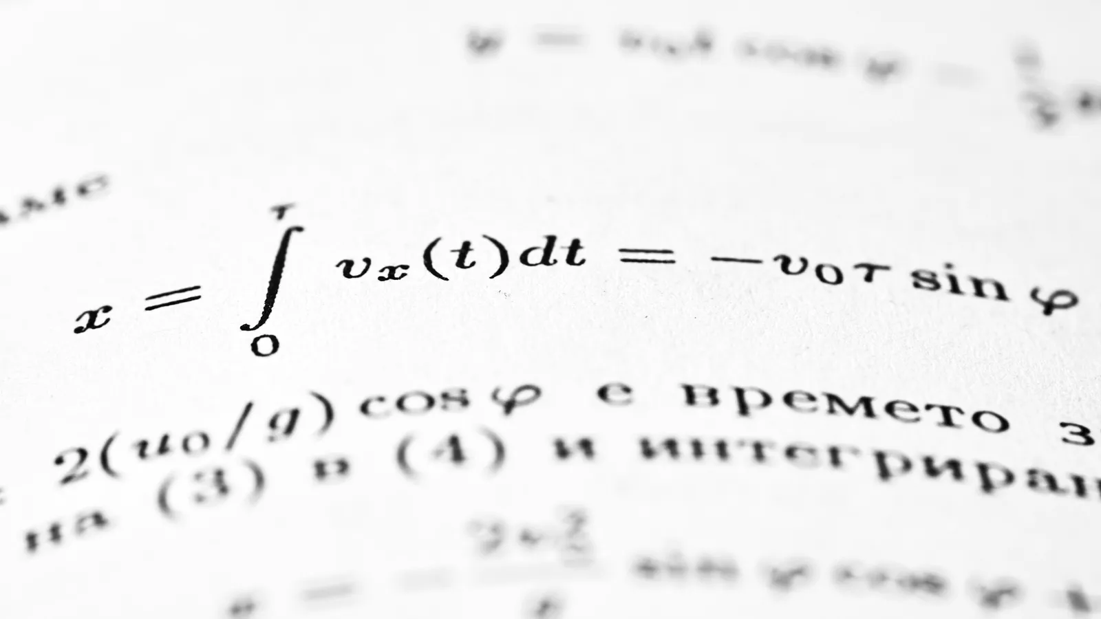 Printed integral equations on a white page, close up
