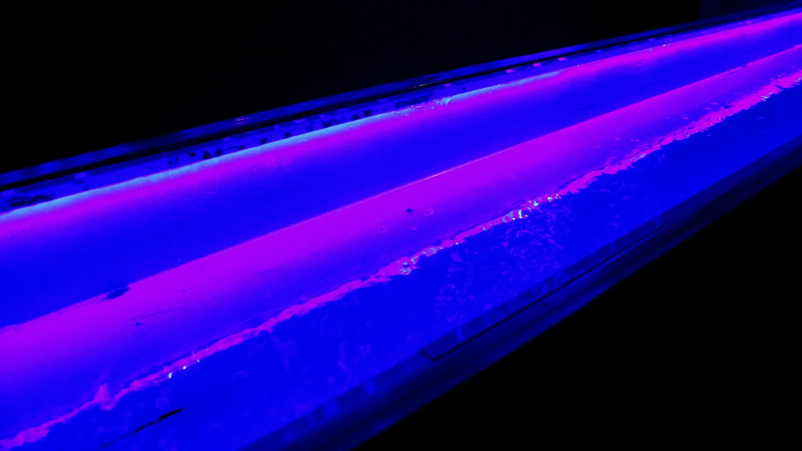 Purple laser beams crossing in the dark