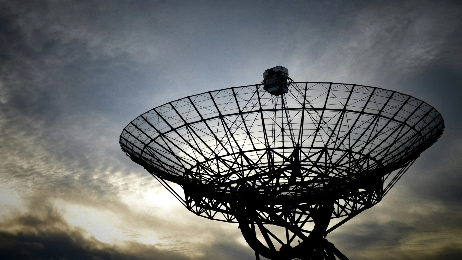 Radio dish antenna against a cloudy sky