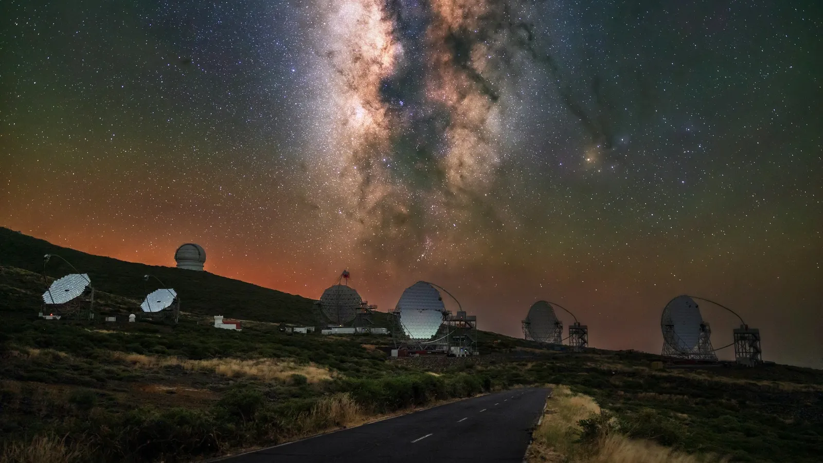 Radio telescope dishes under the Milky Way at night