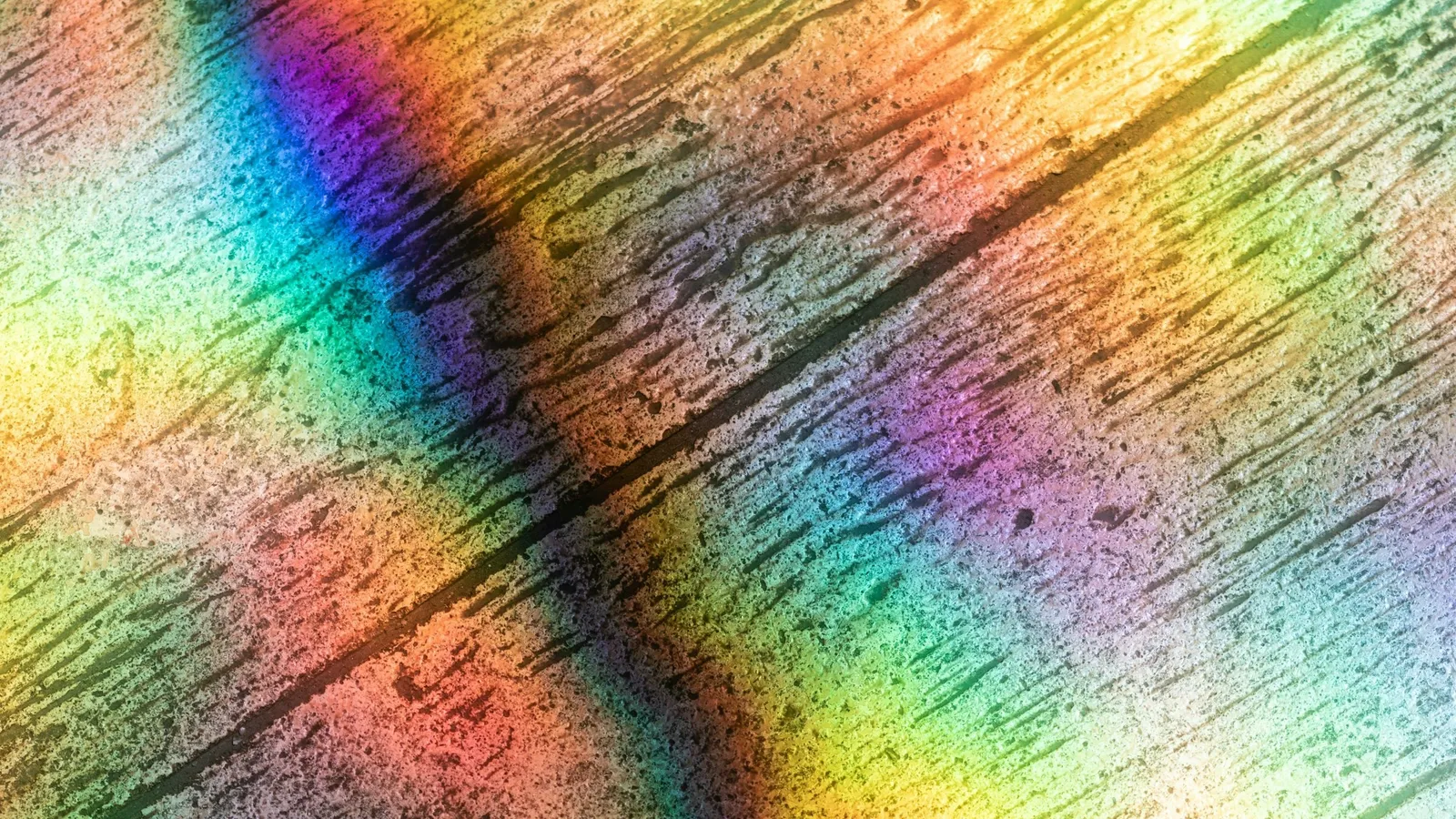 Rainbow bands of diffracted light across a finely grooved surface