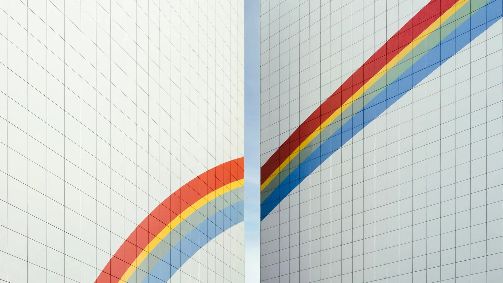 Rainbow-coloured curves painted across a white tiled wall