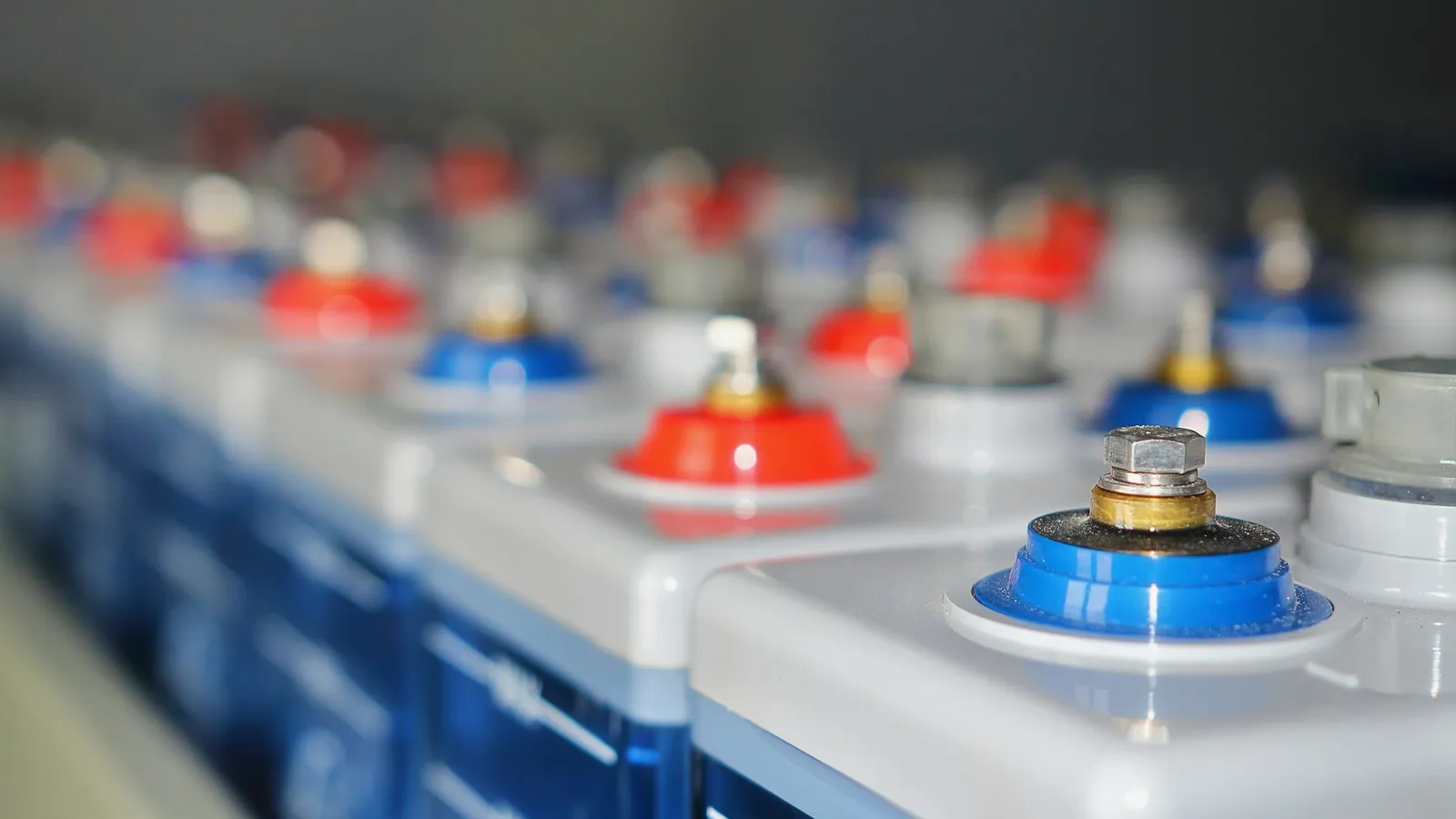 Rows of large battery cells with red and blue terminals