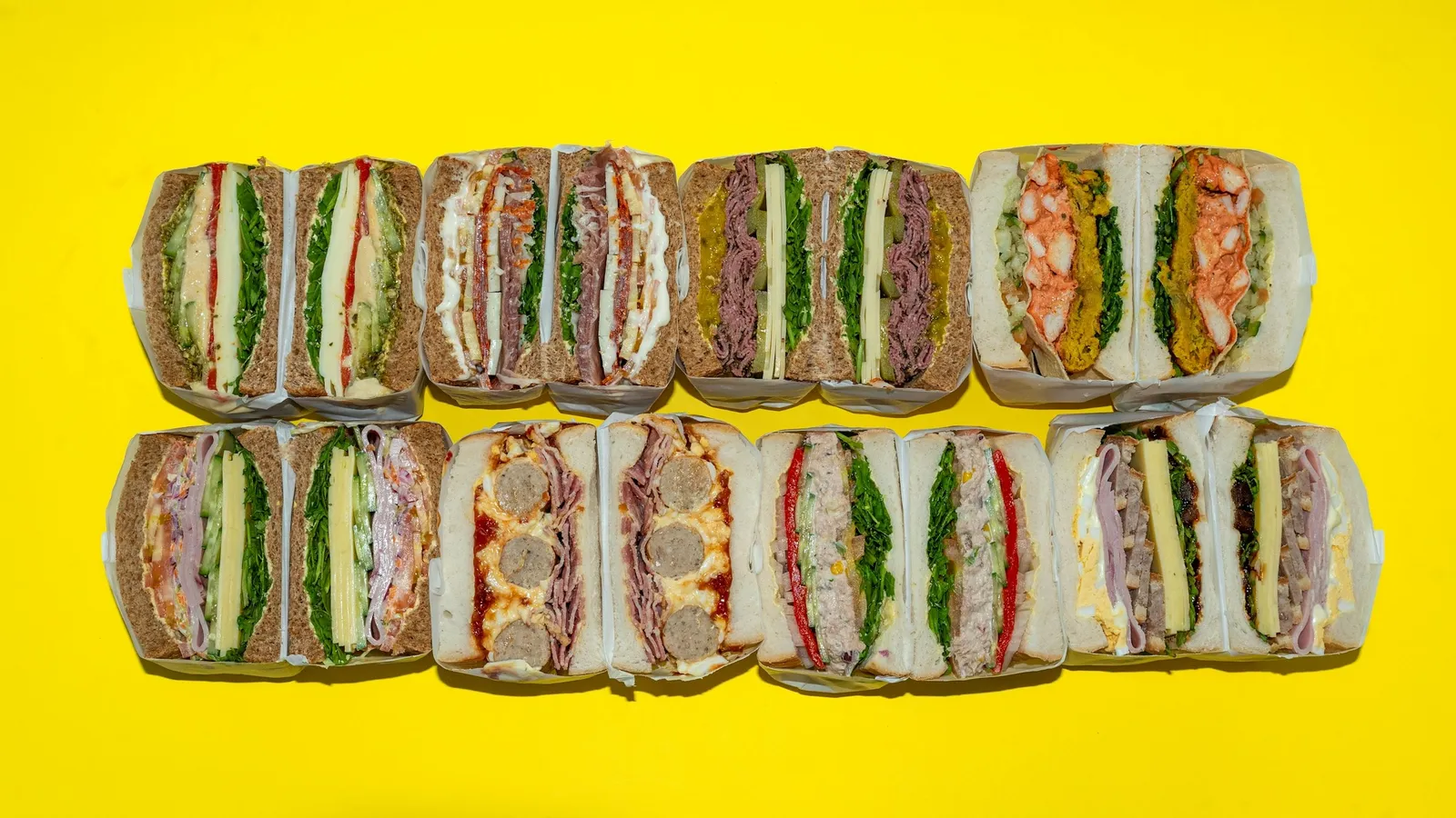 Rows of sandwiches lined up on a yellow background