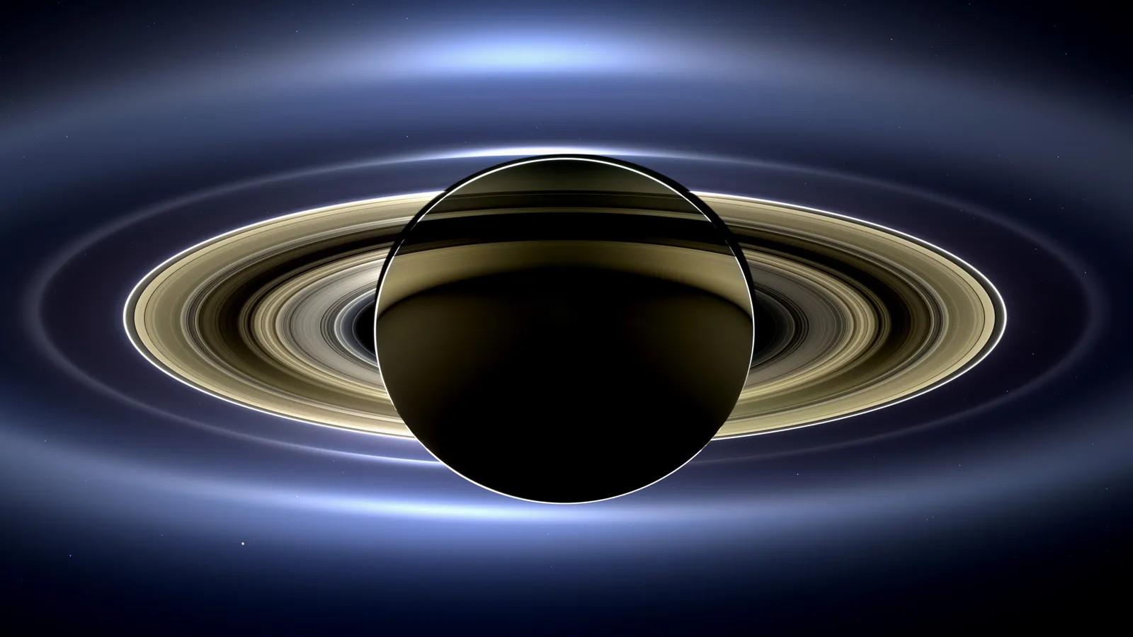 Saturn backlit by the Sun, its rings glowing in a Cassini mosaic