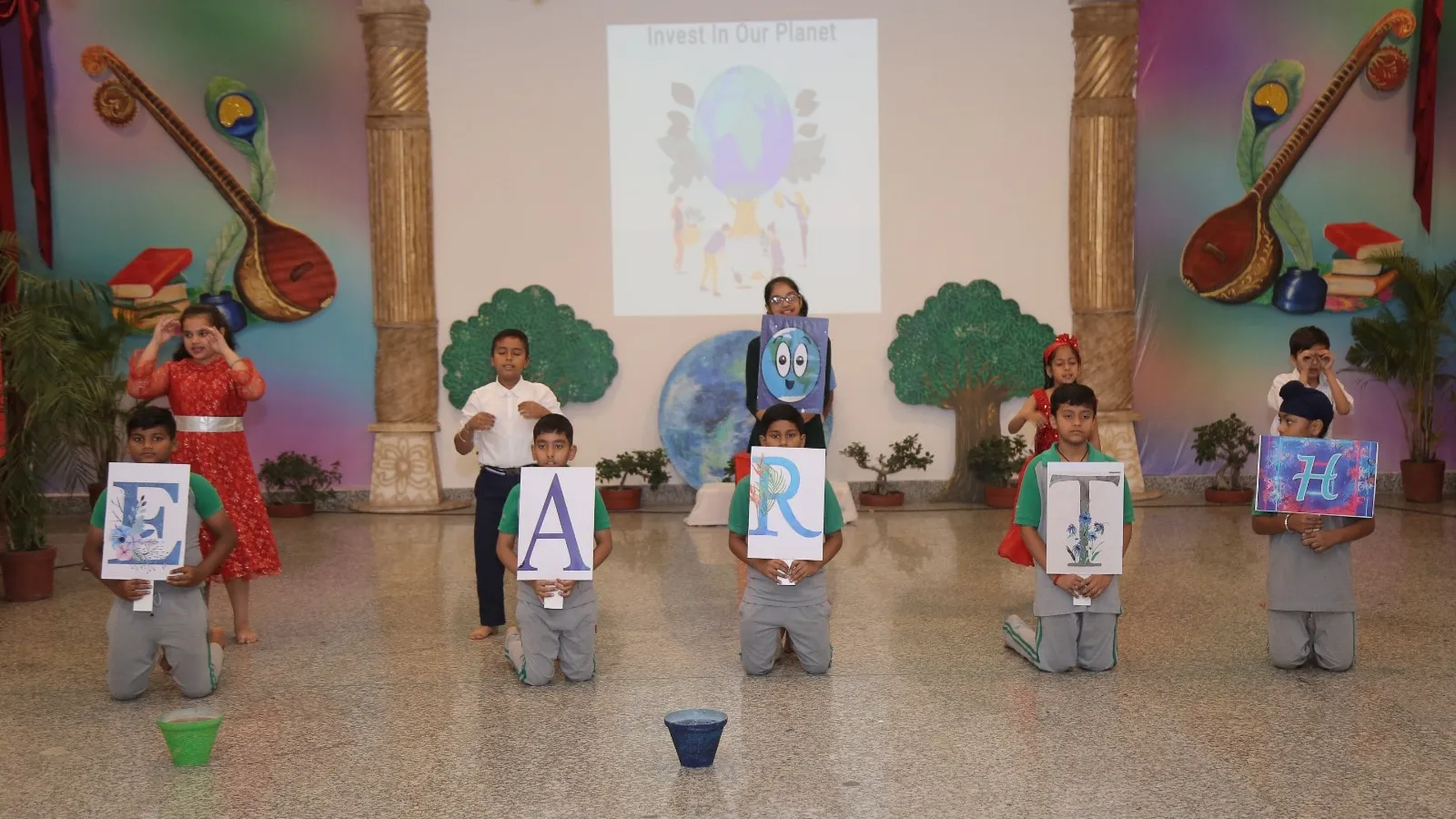 School students performing an Earth Day skit, holding cards that spell EARTH