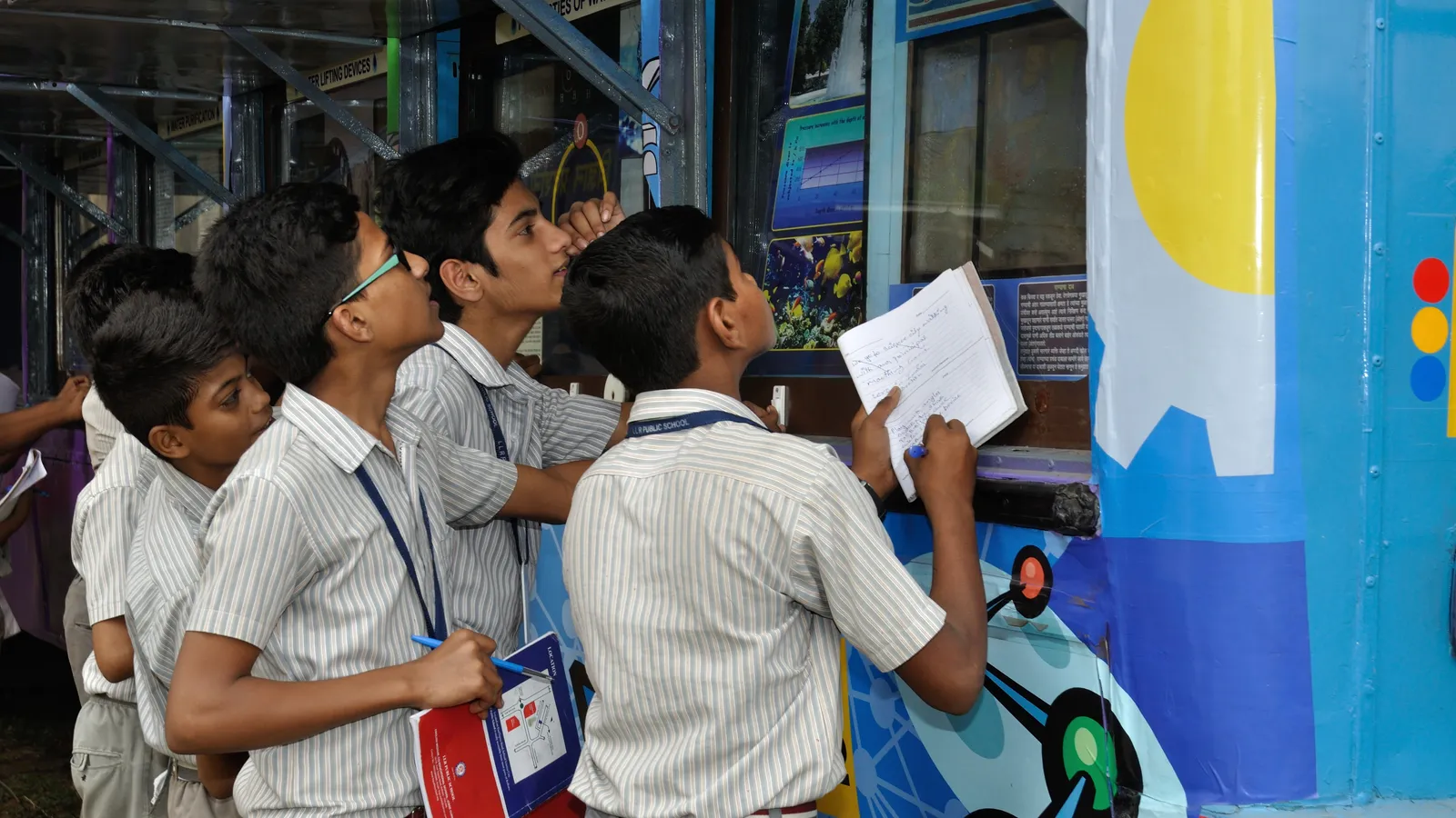 Schoolboys in uniform taking notes at a mobile science exhibition in Kolkata