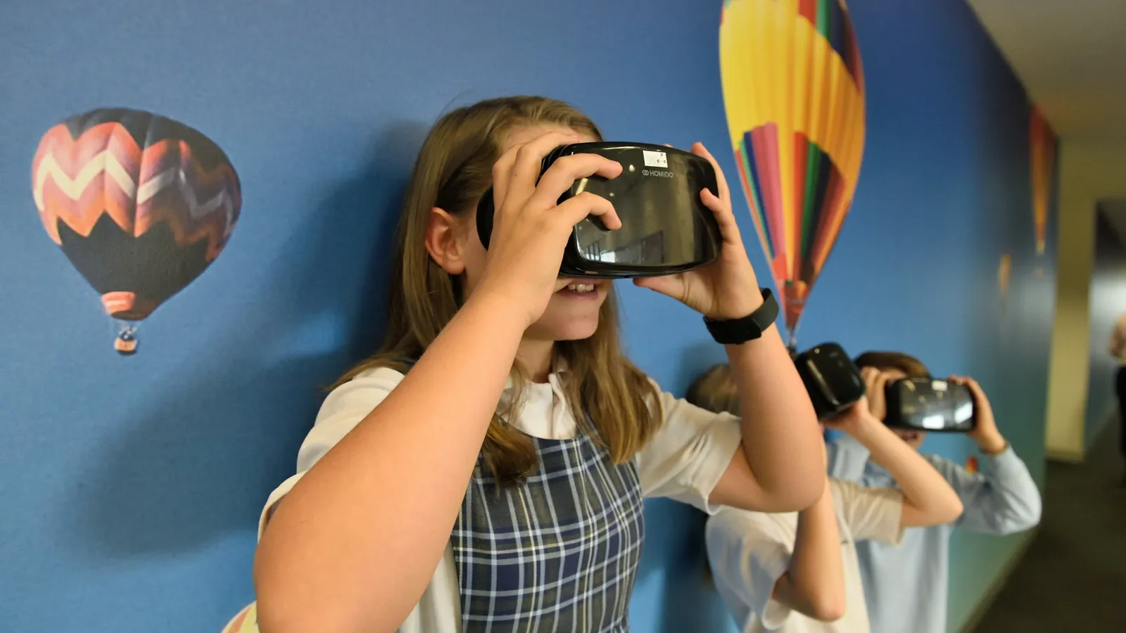 Schoolchildren wearing virtual reality headsets in a classroom