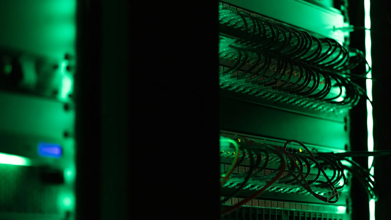 Server racks lit with green lights in a data centre
