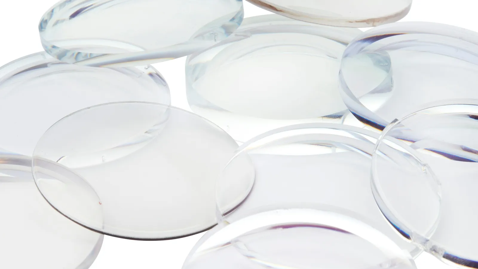 Several clear glass lenses scattered on white
