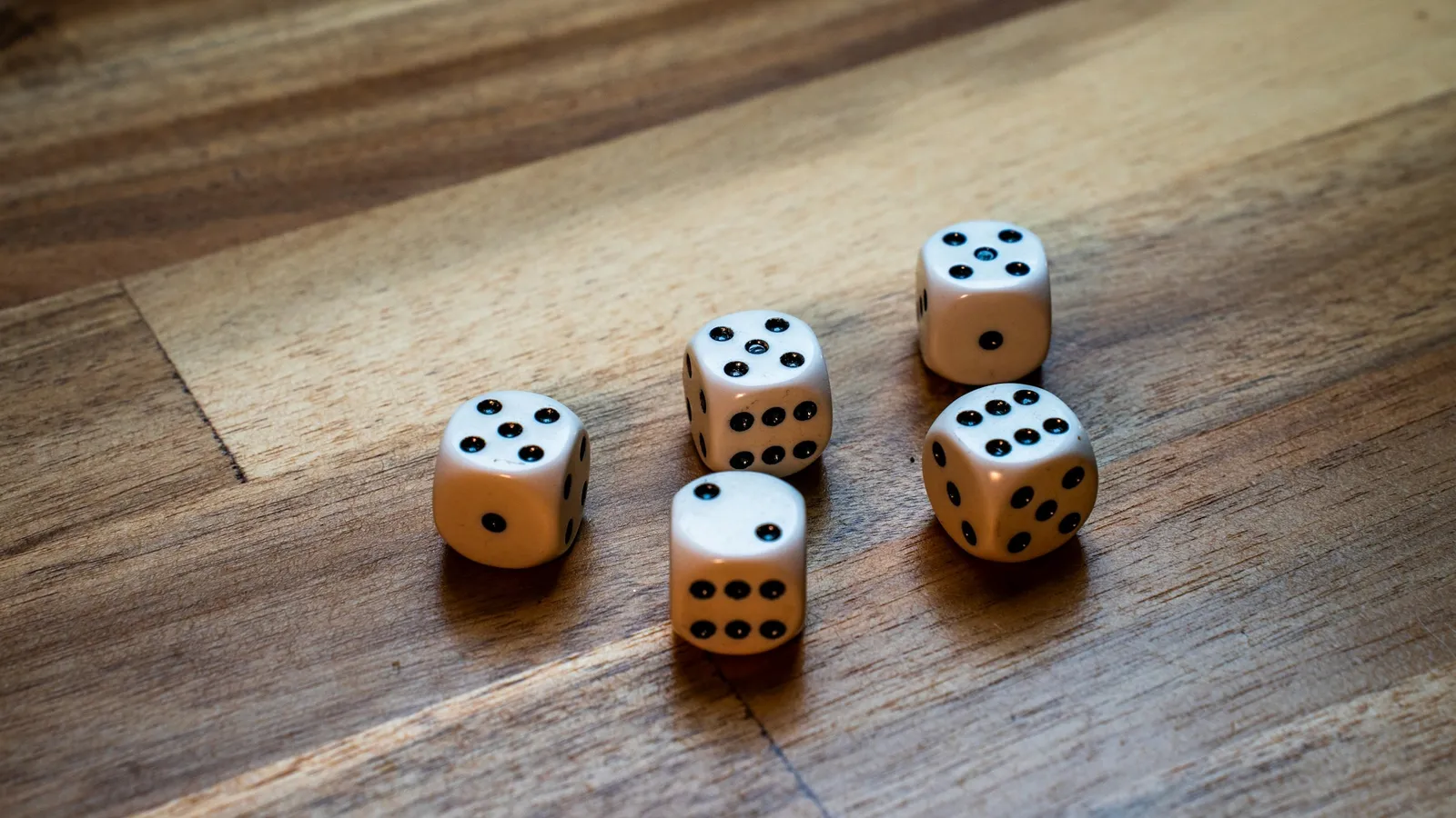 Several dice scattered on a wooden table