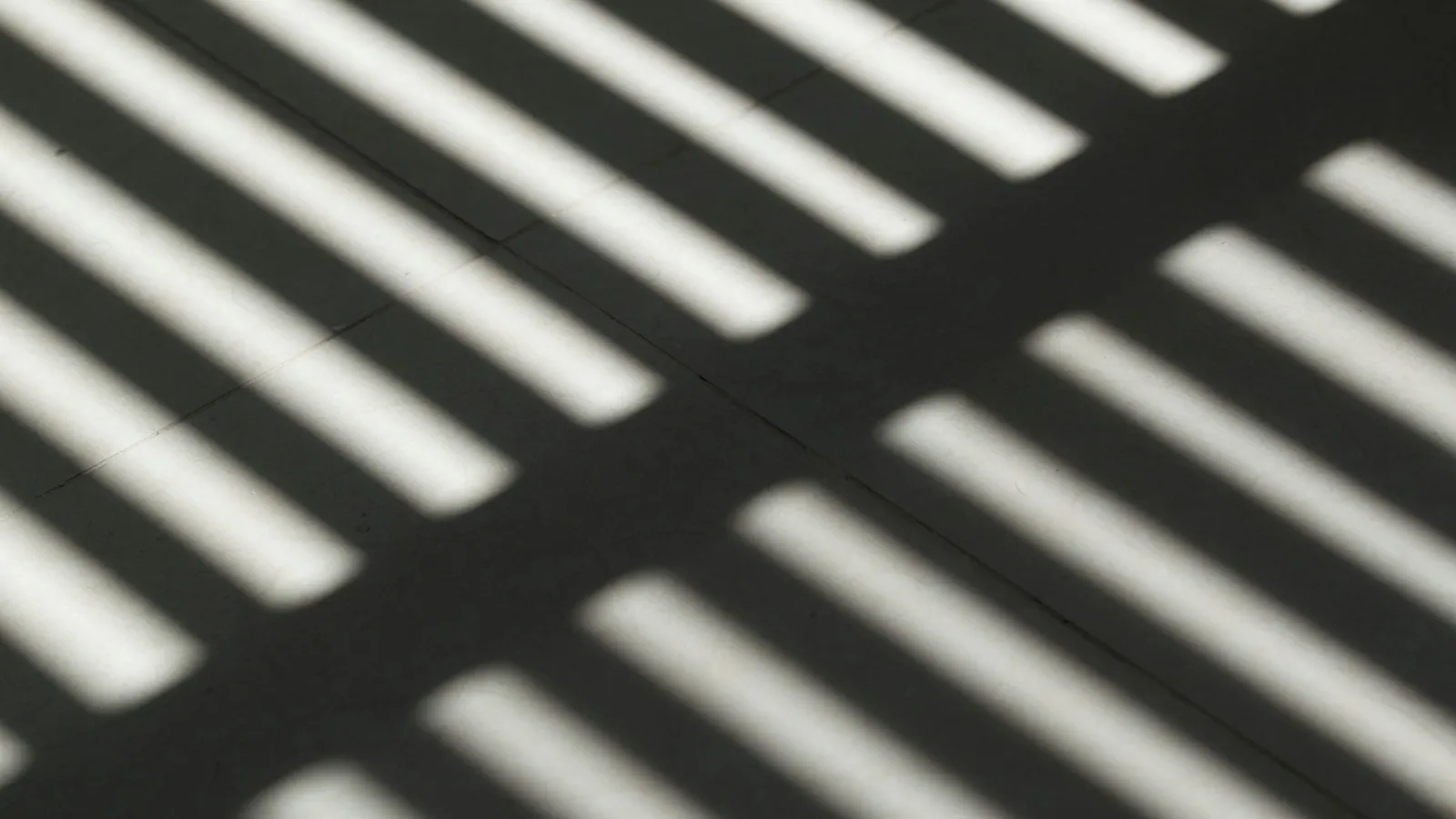 Sharp stripes of sunlight and shadow on a wall