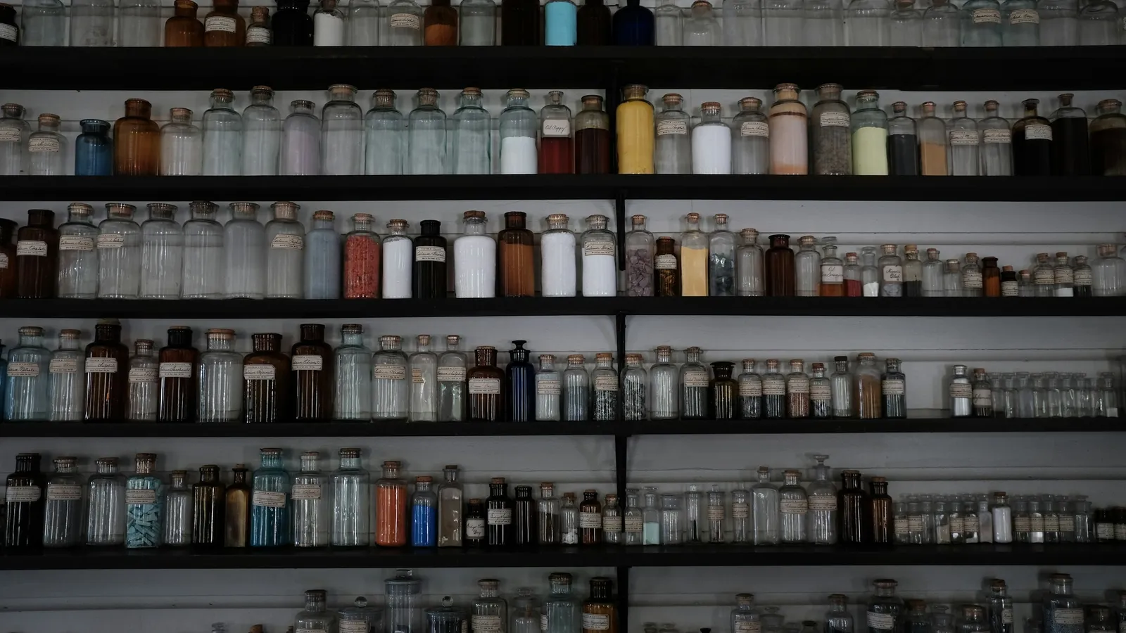 Shelves lined with rows of chemical reagent bottles