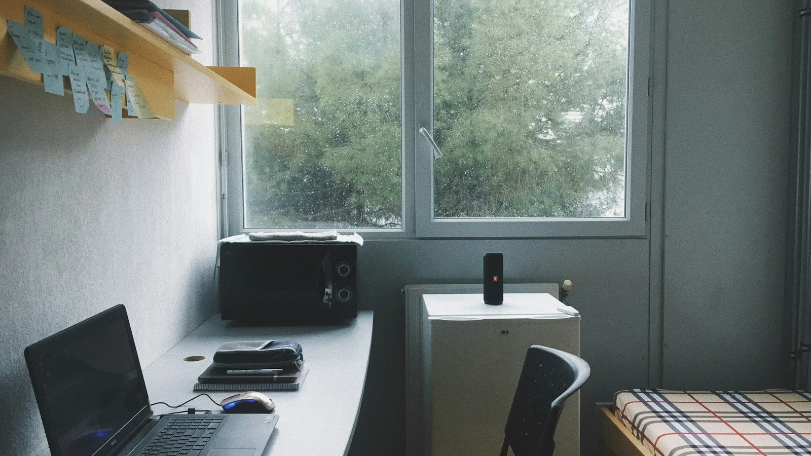 Small room with a desk and laptop by a window