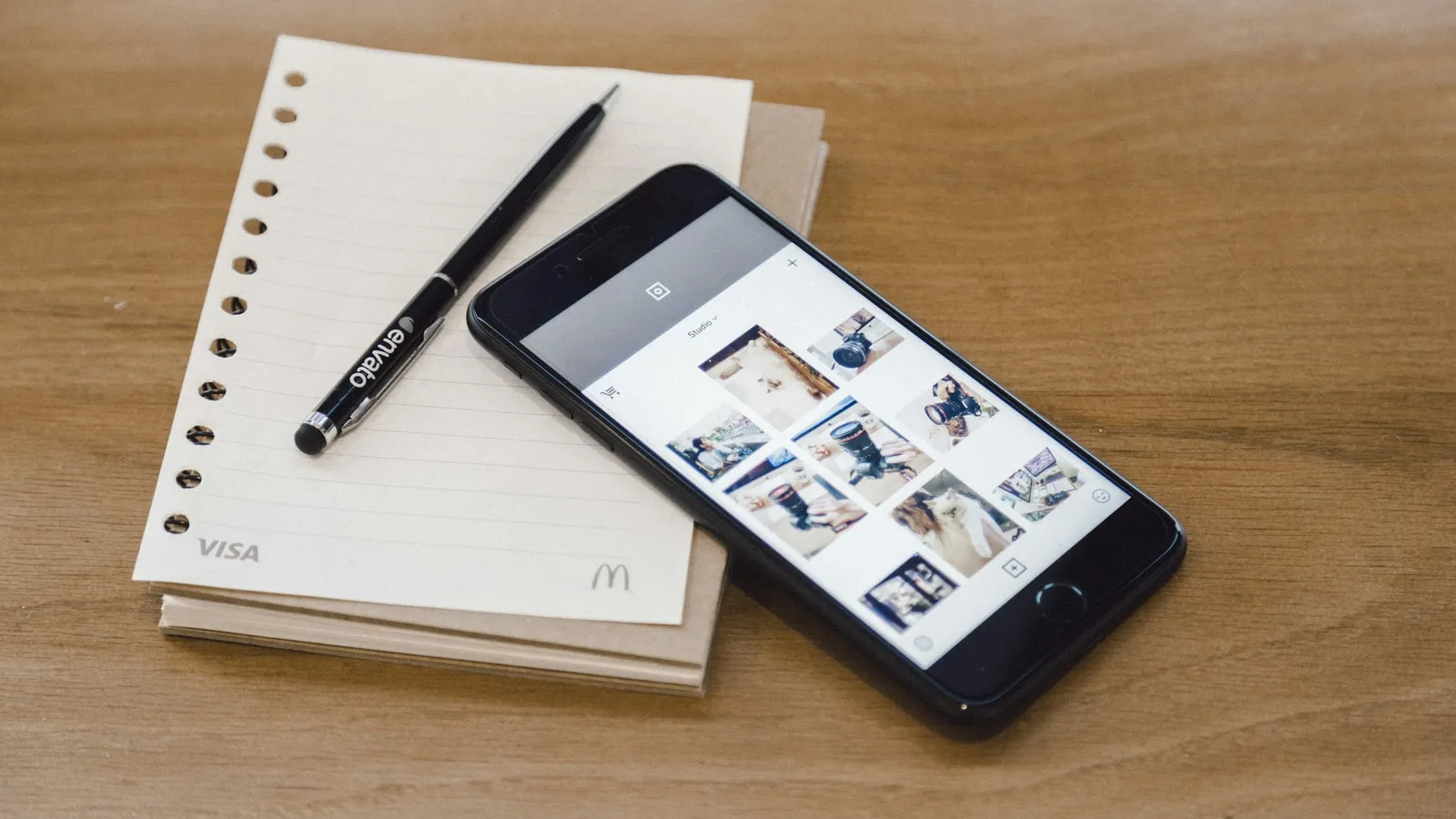Smartphone lying on a notebook with a pen