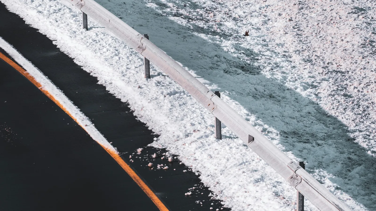 Snow along the edge of a wet road in winter