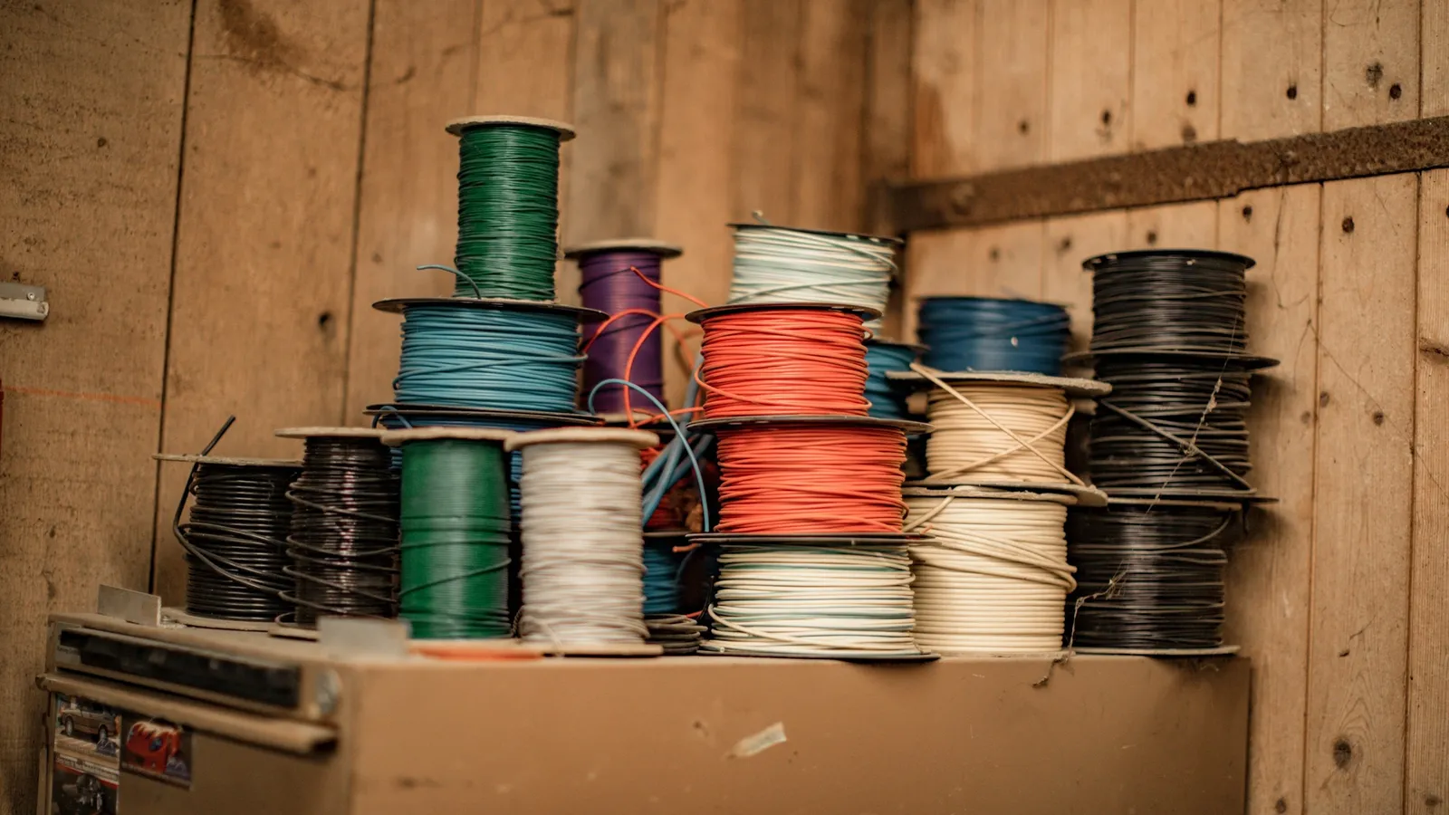 Spools of coloured electrical wire on a shelf