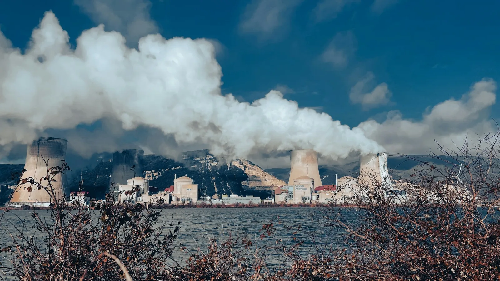 Steam rising from a power station by a lake