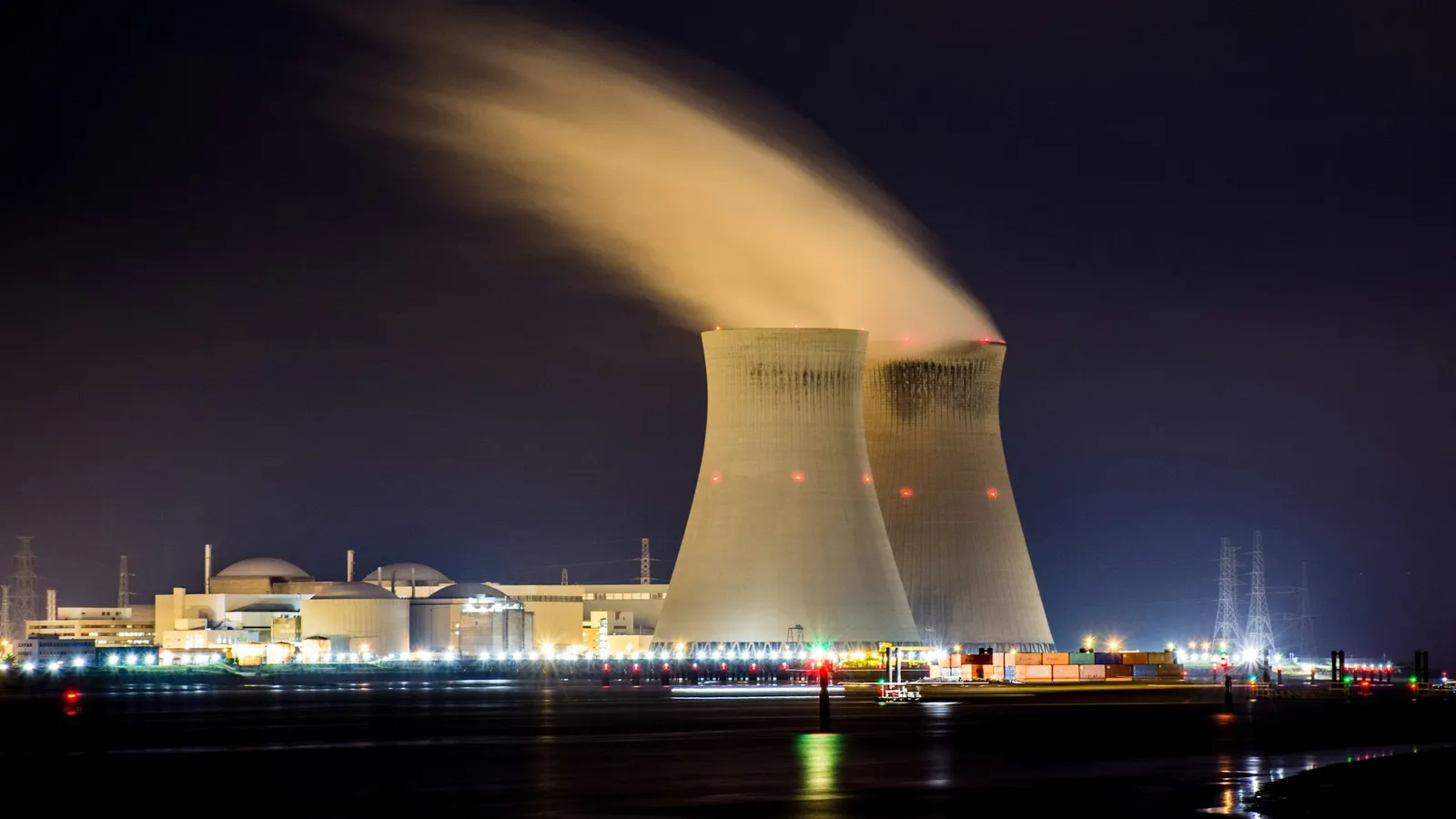 Steam rising from the cooling tower of a nuclear power station at night