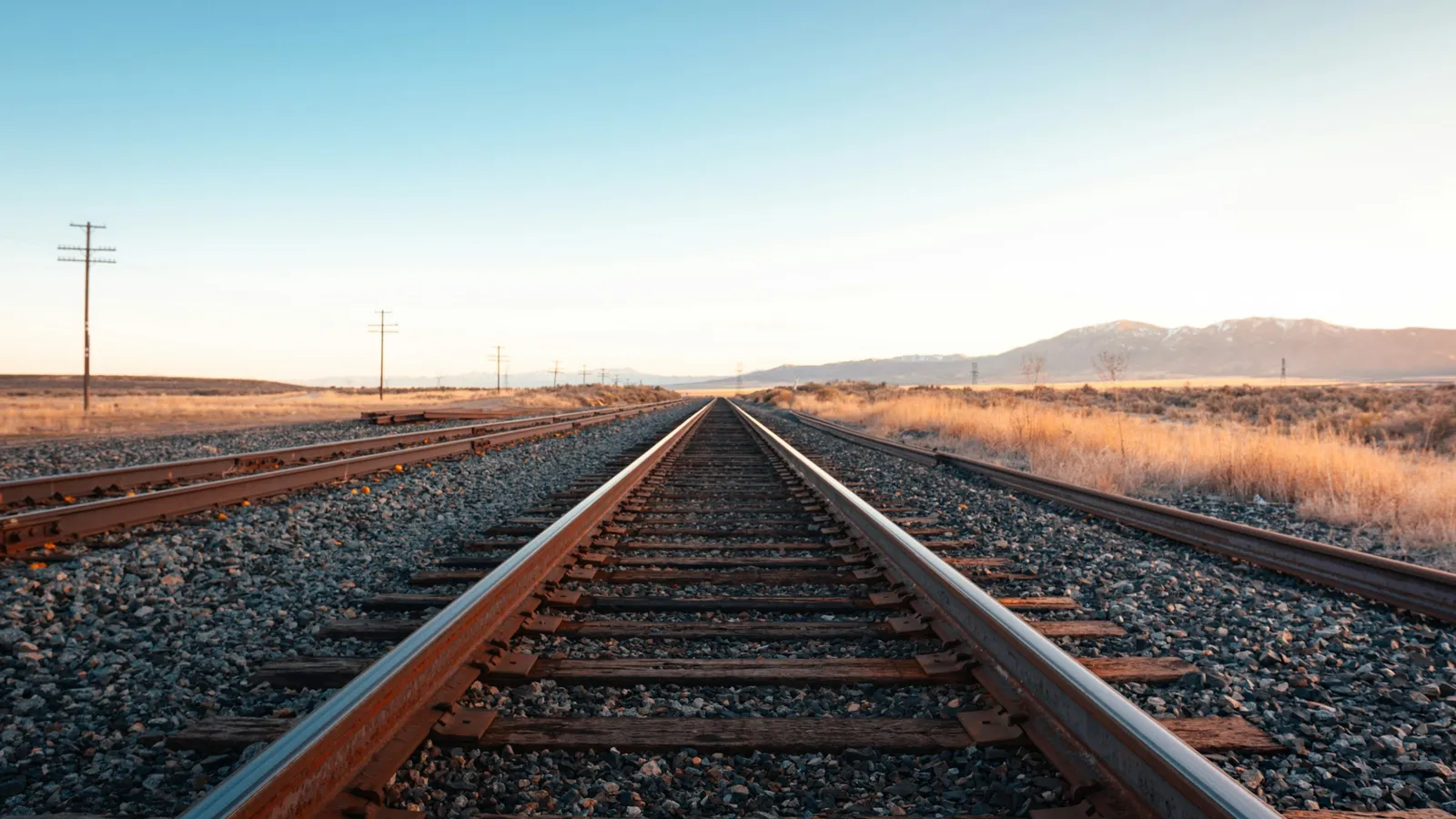 Straight railway tracks running towards the horizon